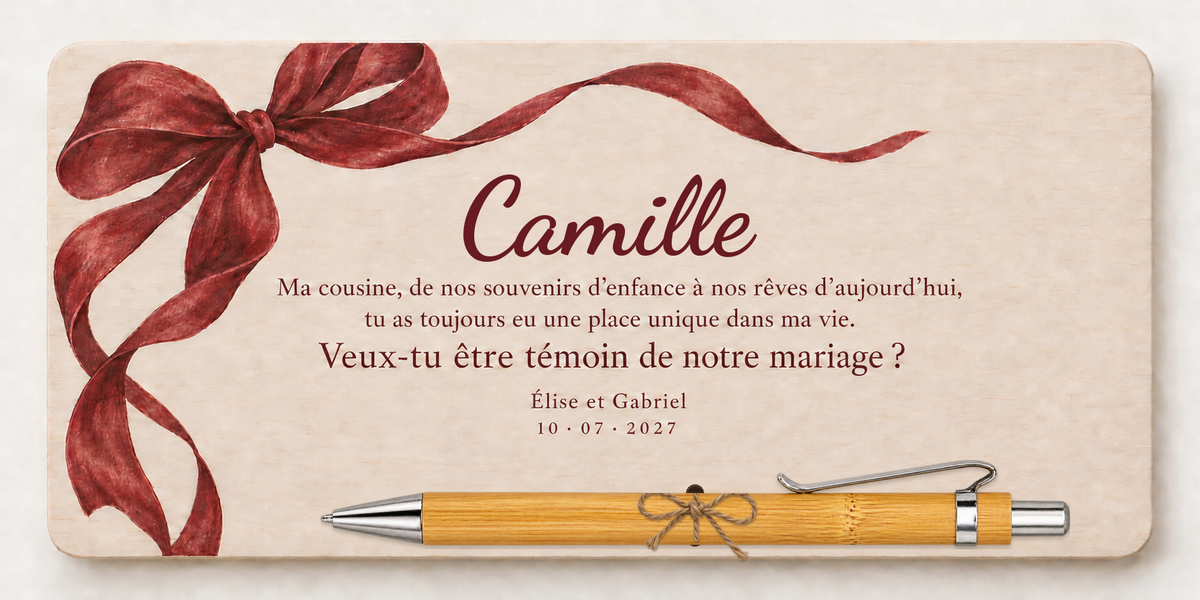 Targa stampata a colori con un fiocco bordeaux, il nome Camille e penna di bambù