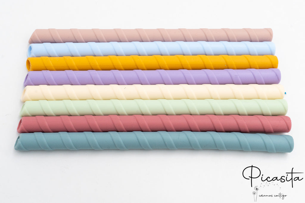 Pajitas de silicona reutilizables alineadas en colores azul, amarillo, lila y rosa.
