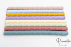 Pajitas de silicona reutilizables alineadas en colores azul, amarillo, lila y rosa.