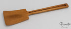 Espátula de madera de acacia con forma rectangular y mango largo con grabado lateral.