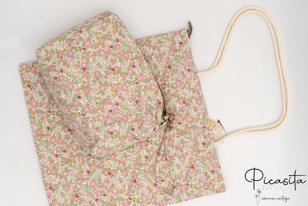 Neceser y bolsa de algodón con estampado floral en tonos rosas y verdes sobre fondo blanco.