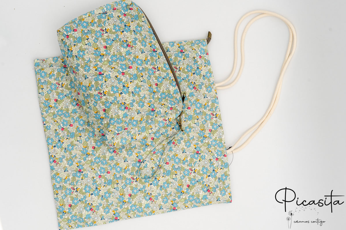 Bolsa y neceser con estampado floral verde sobre fondo blanco de algodón resistente.