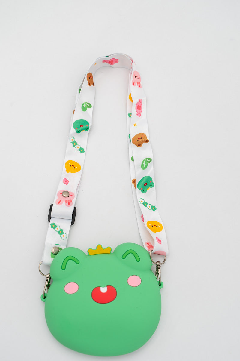 Bolso de silicona verde con forma de rana y detalle de corona amarilla.