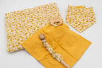 Set senape con copertina a fiori, bavaglino a bandana, mussola senape con massaggiagengive a orsetto in legno e catenella portaciuccio con clip in legno.