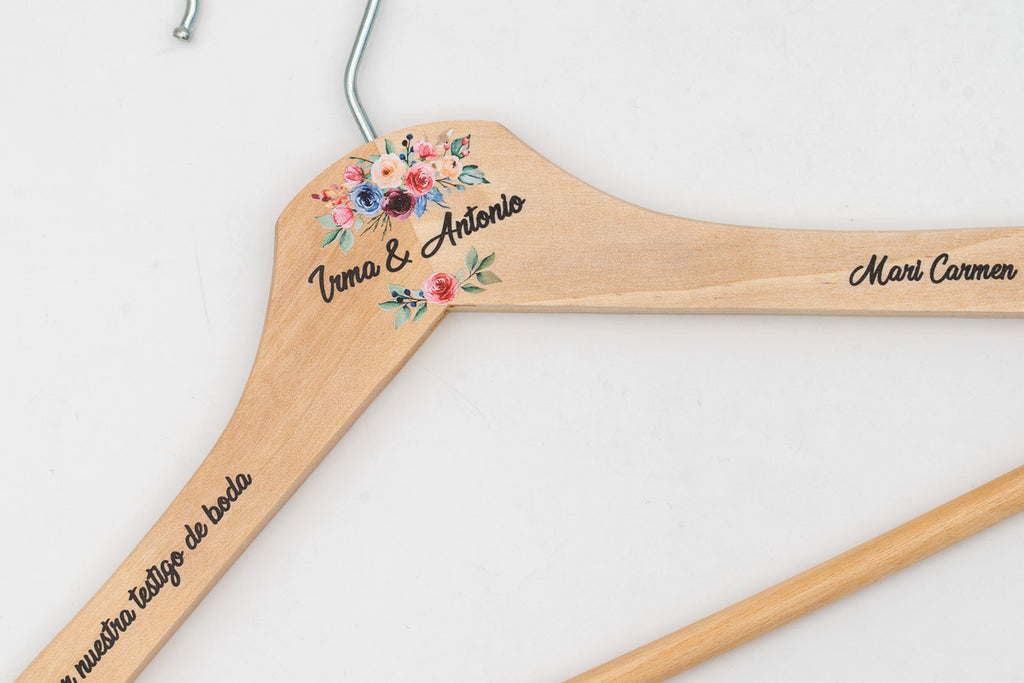 Percha de madera clara personalizada con nombres y flores, detalle del hombro
