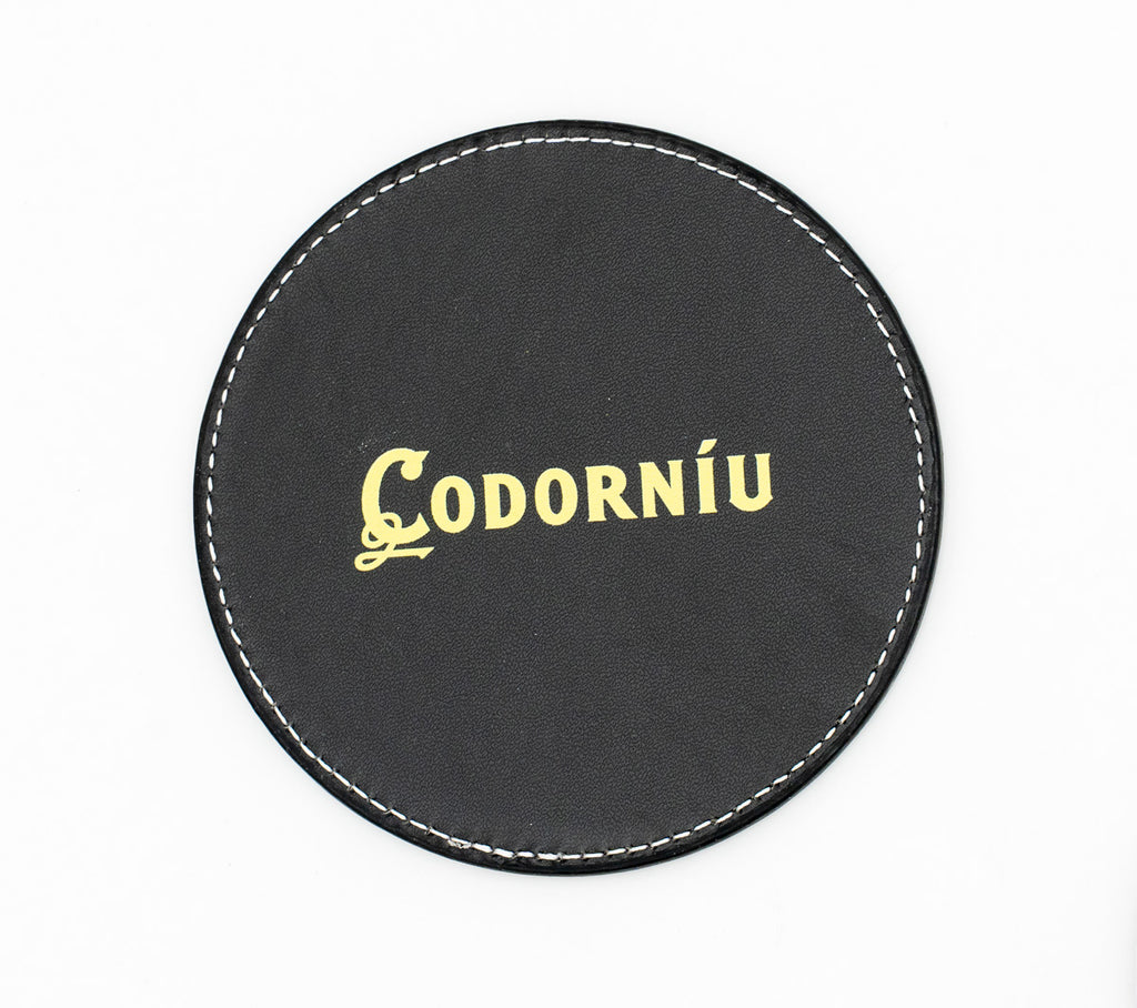 Sottobicchiere rotondo nero con logo Codorníu di tonalità dorata.
