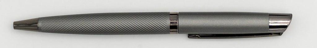 Penna in metallo grigio con parte superiore liscia e corpo a linee diagonali.