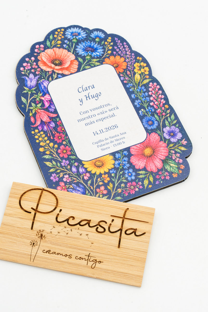 Partecipazione di matrimonio in legno con fiori selvatici colorati su sfondo blu marino