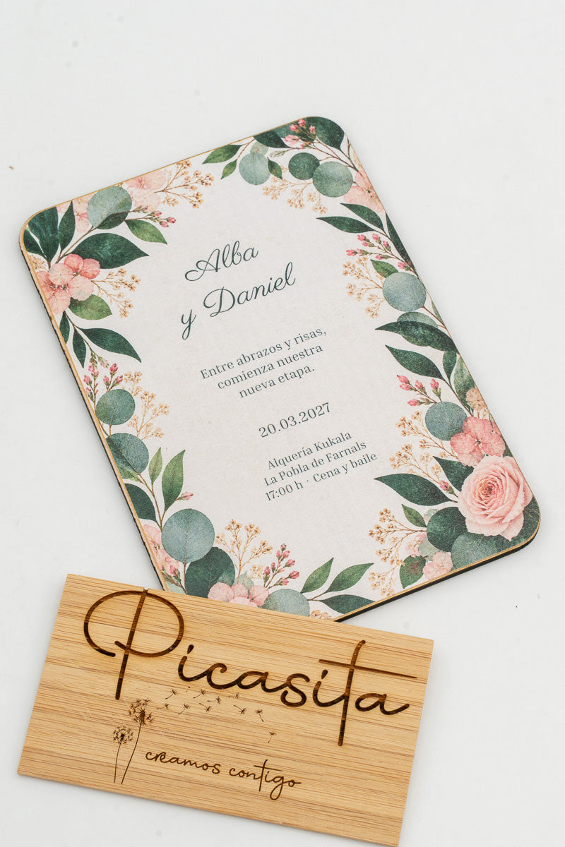 Partecipazione di matrimonio in legno con foglie di eucalipto e rose agli angoli