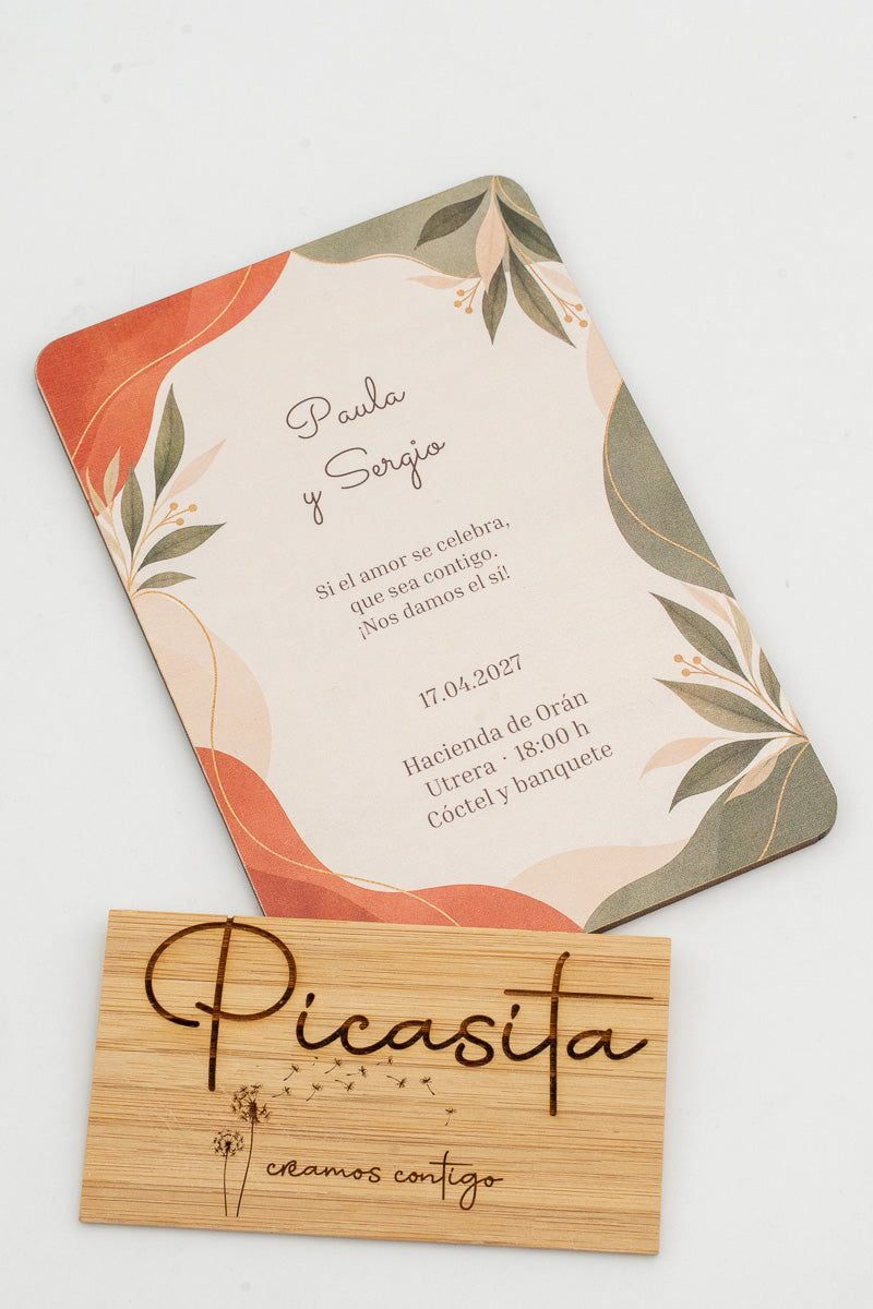 Partecipazione di matrimonio in legno con foglie in toni terracotta e verde salvia