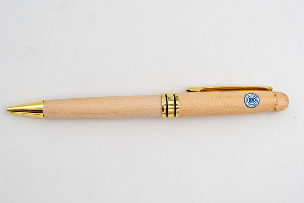Penna in legno chiaro con simbolo circolare a colori e dettagli dorati.