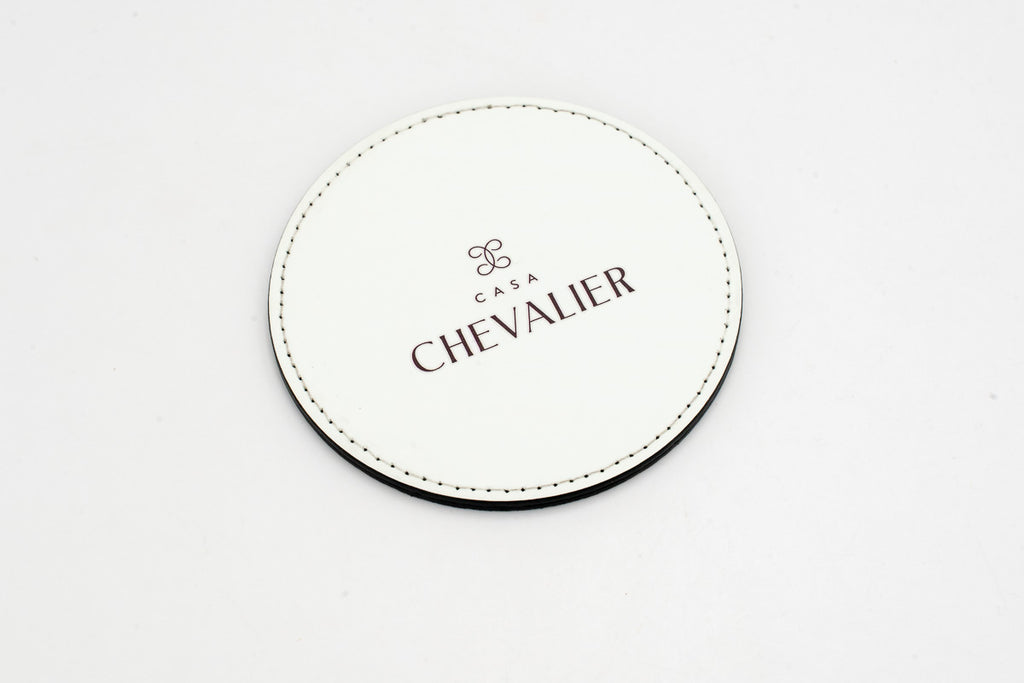 Sottobicchiere rotondo bianco con logo Chevalier grigio.