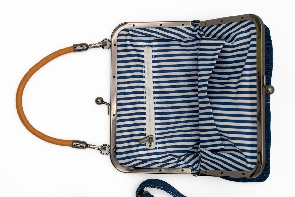Interno della borsa con fodera a righe bianche e blu e tasca interna con cerniera