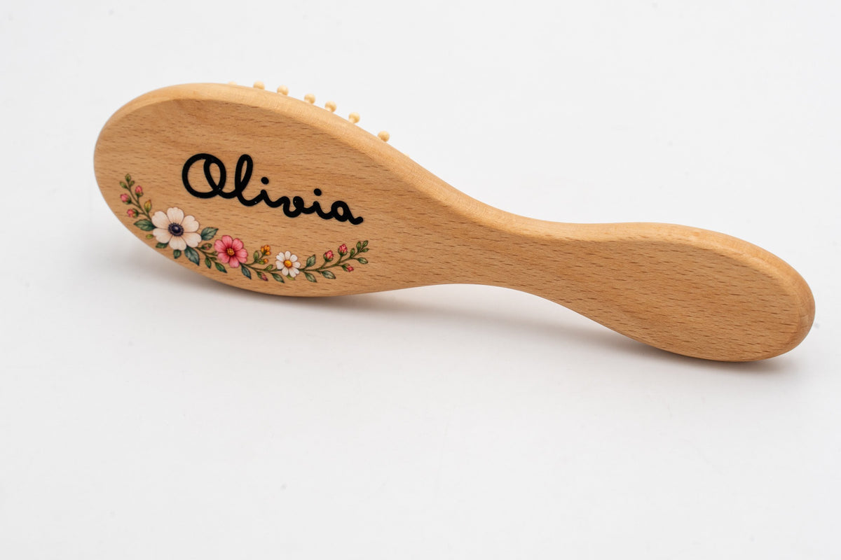 Spazzola in legno con il nome Olivia e motivo floreale a colori.