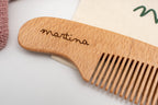 Dettaglio di un pettine in legno con il nome Martina inciso.