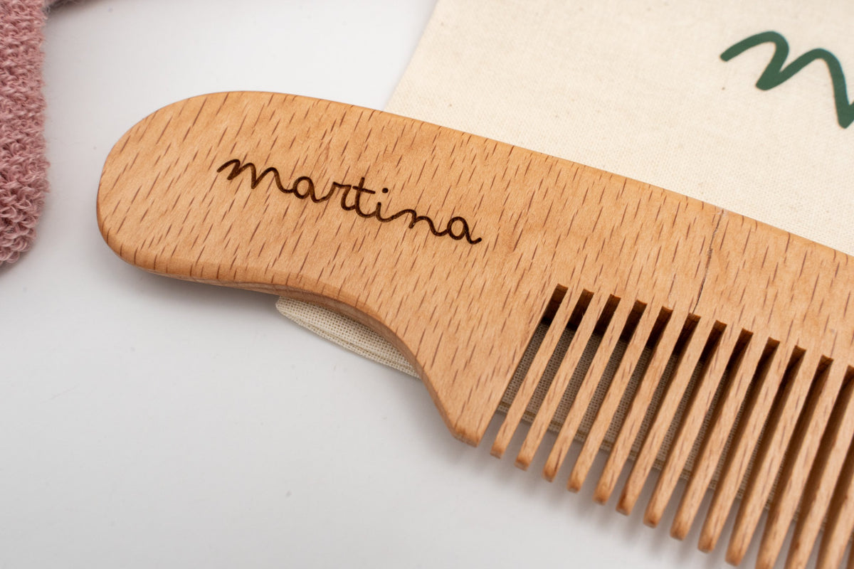 Dettaglio di un pettine in legno con il nome Martina inciso.