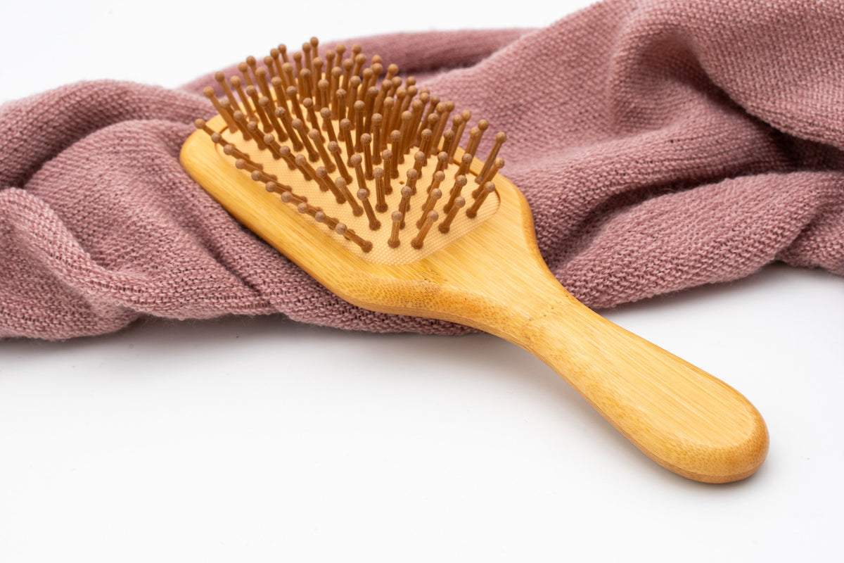 Spazzola rettangolare con dentini in legno vista frontalmente.