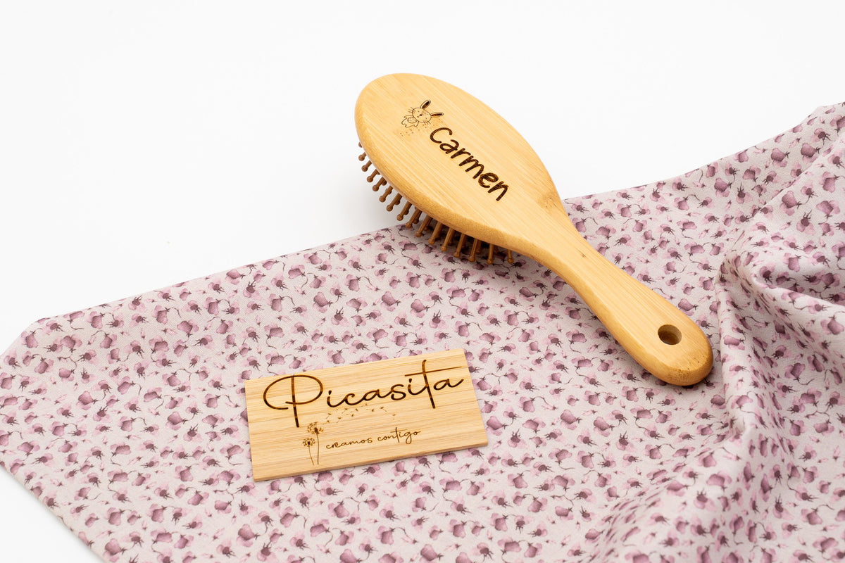Spazzola in legno arrotondata con il nome Carmen inciso.