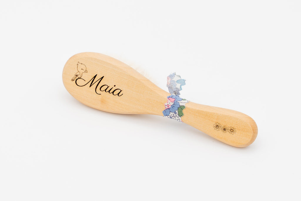 Spazzola in legno con il nome Maia e ortensie blu.