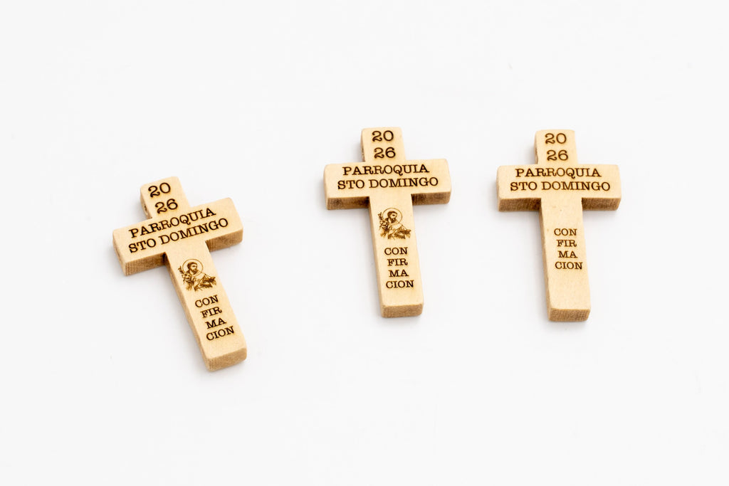 Tres cruces de madera clara con inscripciones oscuras para recuerdo