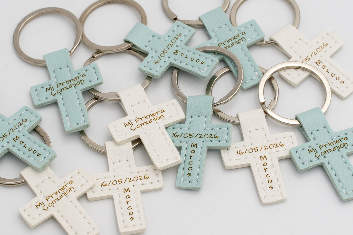 Varios llaveros de cruz en tonos pastel con anilla y textos personalizados