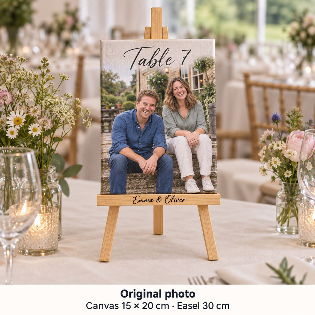 Tela di 15 × 20 cm con foto prematrimoniale di Emma e Oliver e «Table 7», su cavalletto al tavolo del ricevimento.