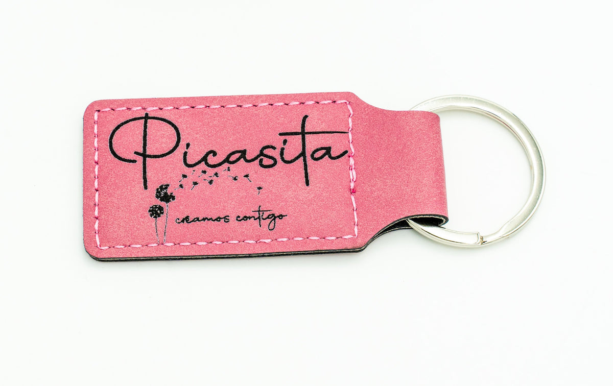Portachiavi rettangolare rosa con logo scuro di Picasita.