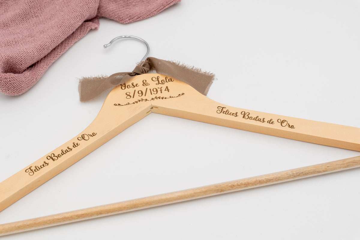 Gruccia di legno con i nomi José e Lola e «Felices Bodas de Oro» incisi, con fiocco marrone