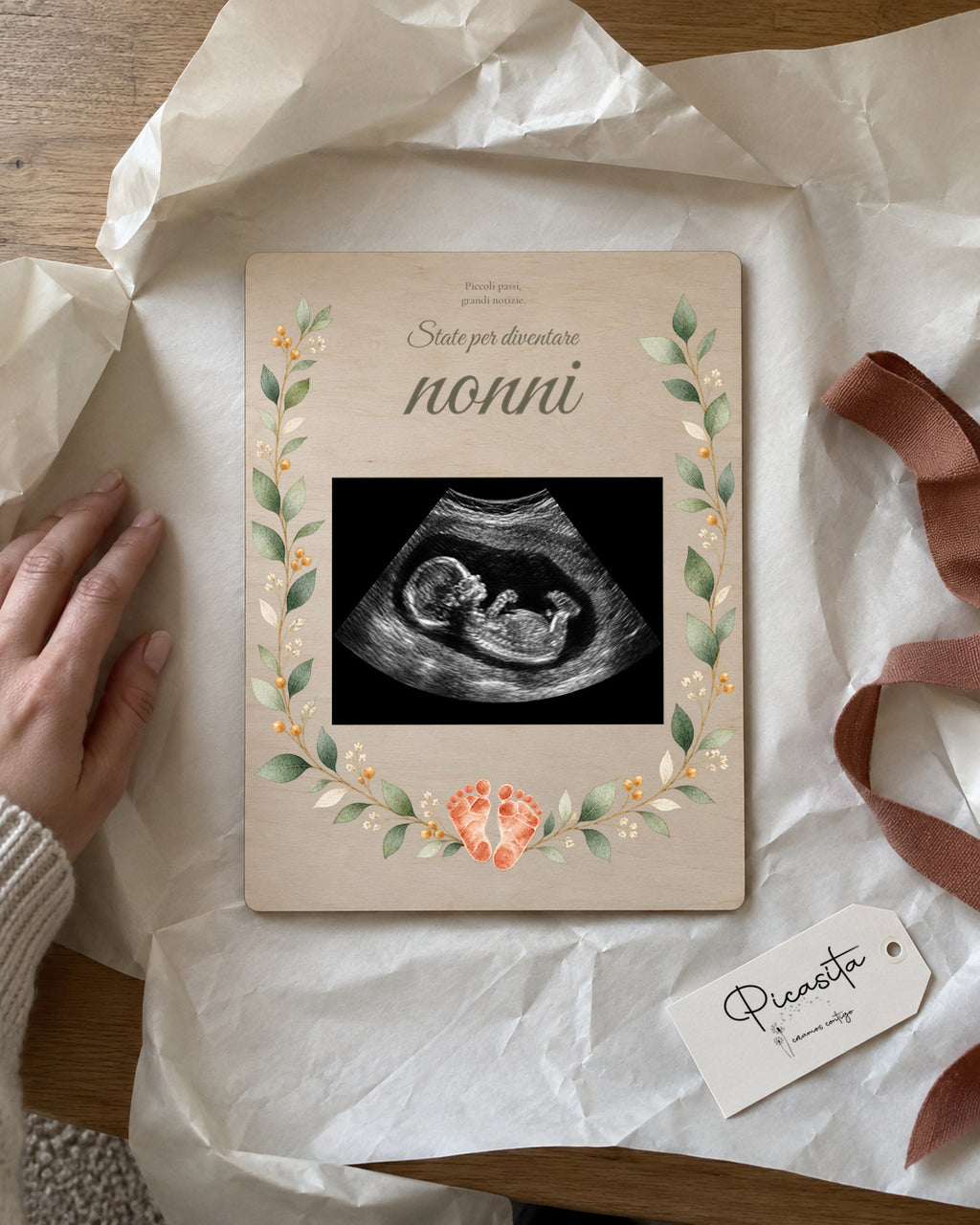 Anteprima simulata: Piccole impronte su Compensato, 15 × 20 cm, con ecografia sintetica illustrativa. Scena regalo.