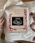 Anteprima simulata: Prima foto su Compensato, 15 × 20 cm, con ecografia sintetica illustrativa. Scena regalo.