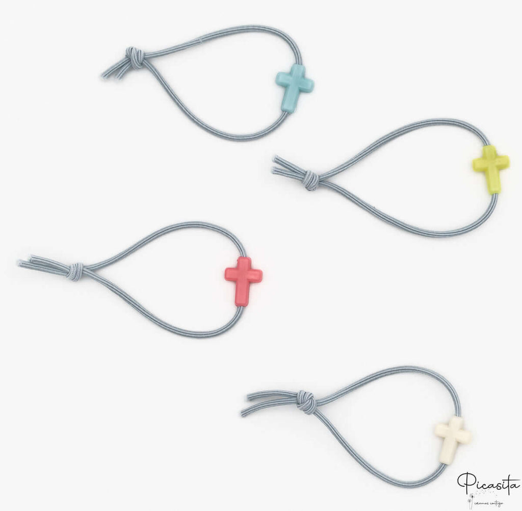 Cuatro pulseras grises infantiles con cuentas de silicona en forma de cruz de varios colores.