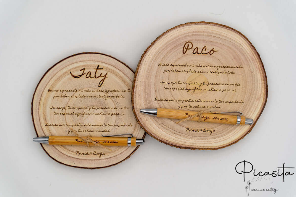 Due fette di legno incise per i testimoni Saty e Paco, con le loro penne