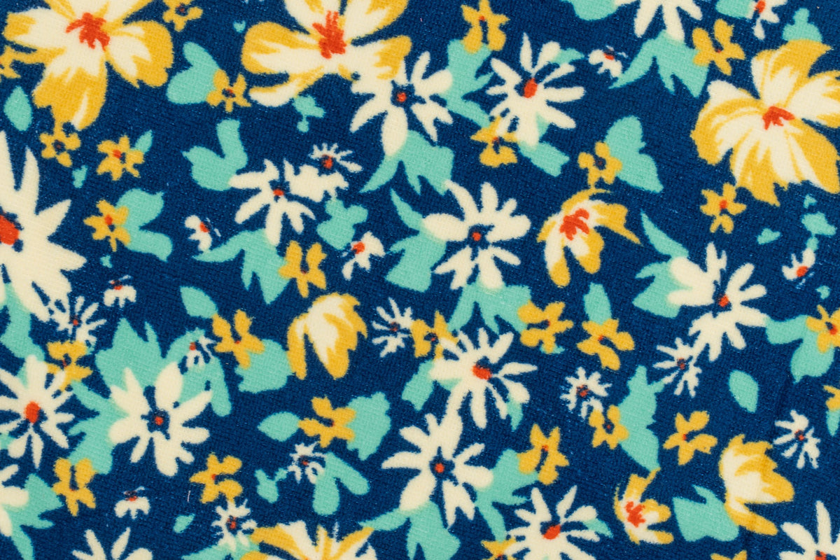 Primo piano di un telo blu navy con fiori bianchi e gialli stampati