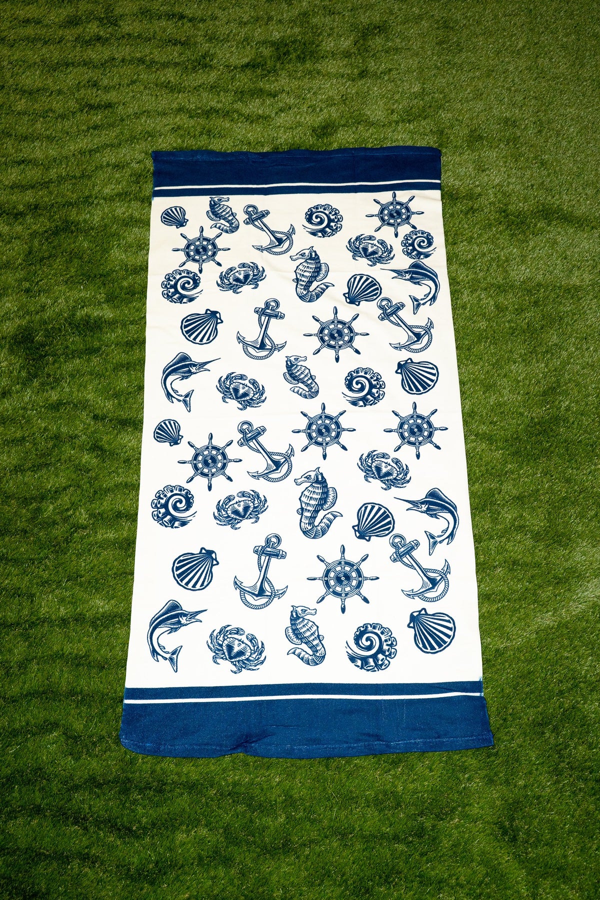 Asciugamano bianco con stampa nautica blu di ancore, conchiglie e timoni