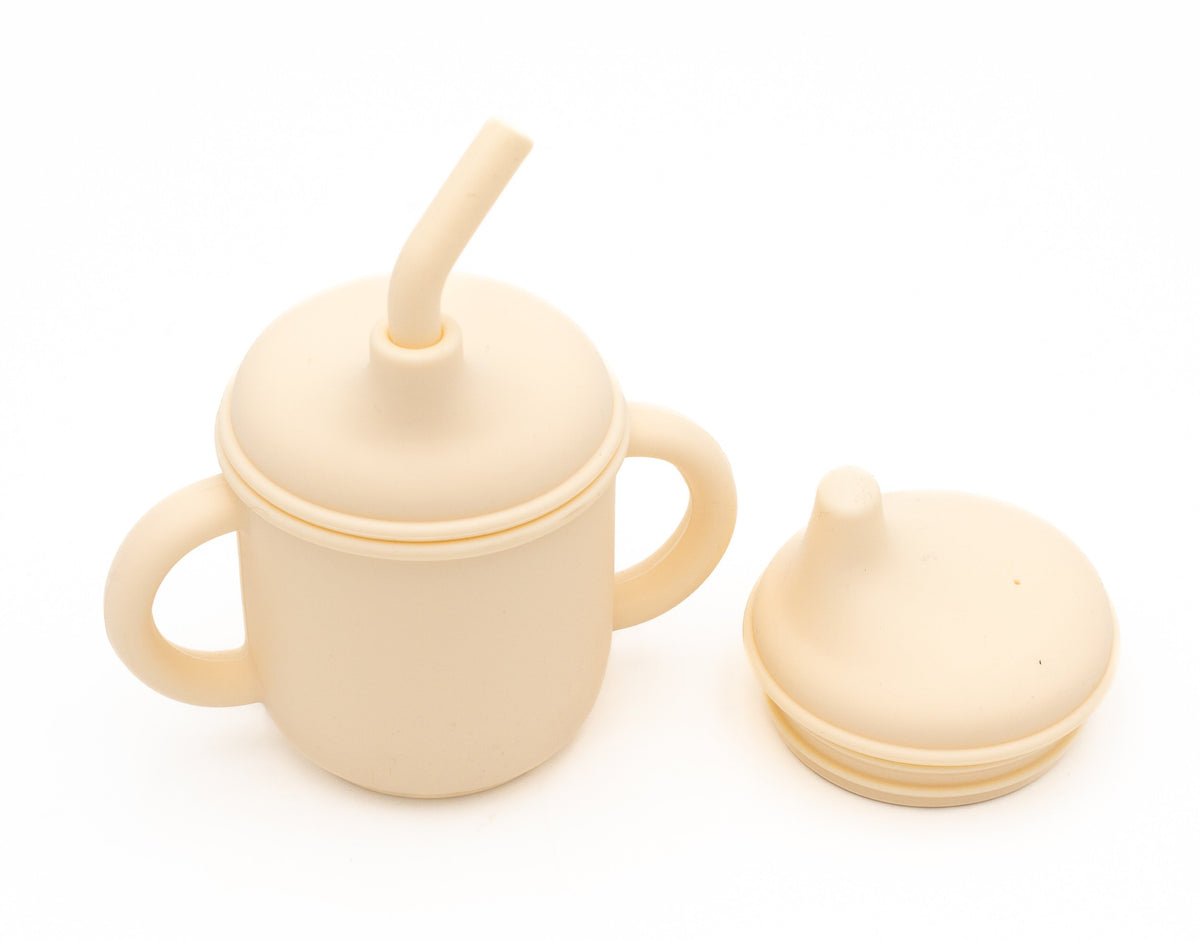 Bicchiere color crema con due coperchi per bere e cannuccia in silicone